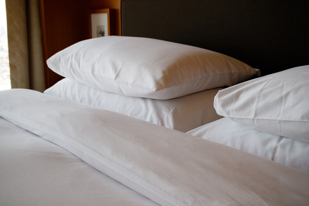 Clean hotel room - pillows on bedの写真素材