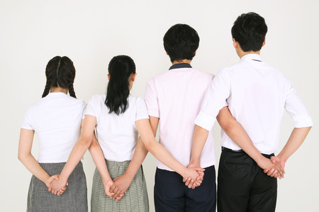 Threee students and their teacher standing and turning back in the studio, isolated on white.の写真素材