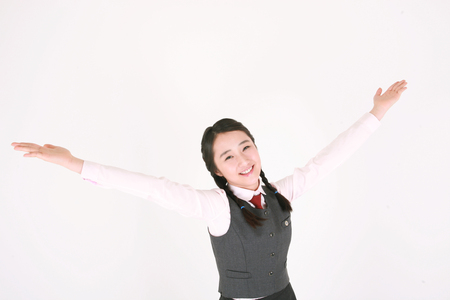 An Asian girl student posing with cute smile in the studio, isolated on white.の写真素材