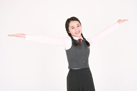 An Asian girl student posing with cute smile in the studio, isolated on white.の写真素材