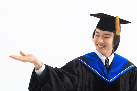 An Asian man with a graduation hat and clothes in the studio, isolated on whiteの写真素材