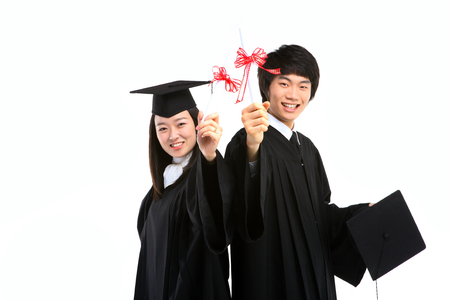 An Asian woman and a man with a graduation hat and clothes in the studio, isolated on whiteの写真素材