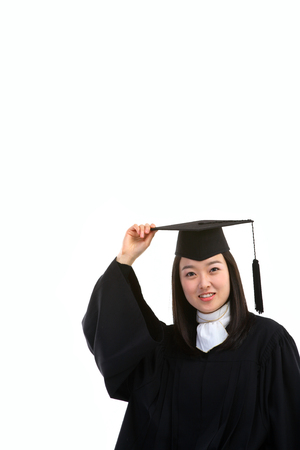 An Asian woman with a graduation hat and clothes in the studio, isolated on whiteの写真素材