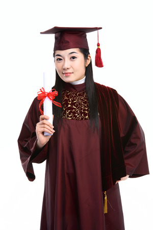 An Asian woman with a graduation hat and clothes in the studio, isolated on whiteの写真素材