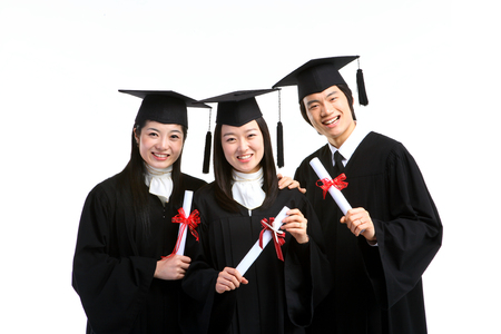 Two Asian women and a man with a graduation hat and clothes in the studio, isolated on white.の写真素材