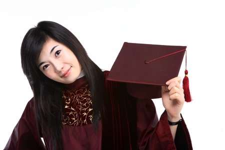 An Asian woman with a graduation hat and clothes in the studio, isolated on whiteの写真素材