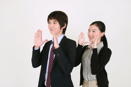 Well dressed young Asian couple posing in the studio - isolated on whiteの写真素材