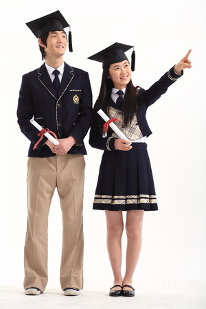 Asian male and female student holding their graduation certificate - isolated on whiteのeditorial素材