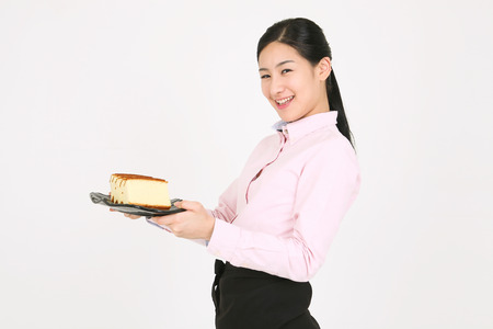 Beautiful young Asian waitress in a studio - isolated on whiteの写真素材
