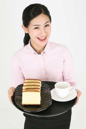 Beautiful young Asian waitress in a studio - isolated on whiteの写真素材