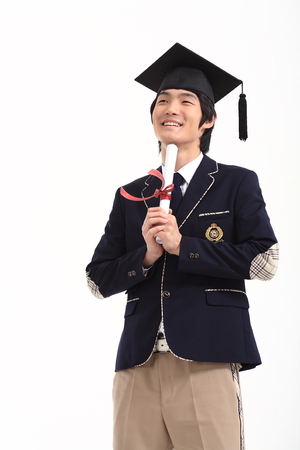 Asian male student wearing graduation cap posing with graduation certificate - isolated on whiteのeditorial素材