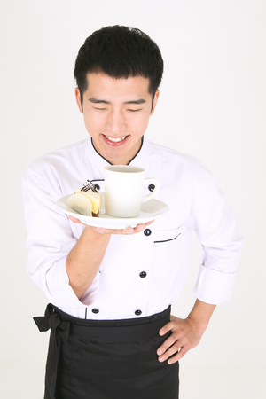Young Asian male chef in a studio - isolated on whiteの写真素材