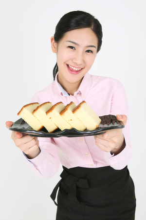 Beautiful young Asian waitress in a studio - isolated on whiteの写真素材