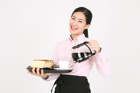 Beautiful young Asian waitress in a studio - isolated on whiteの写真素材