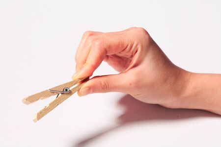 Hand holding a wooden tongs - isolated on white