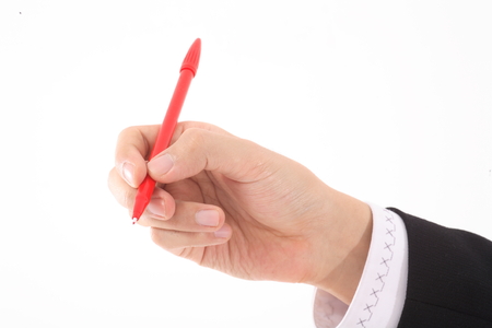Close-up shot of a hand holding a red penの写真素材