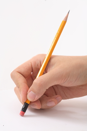 Close-up shot of a hand holding a pencilの写真素材
