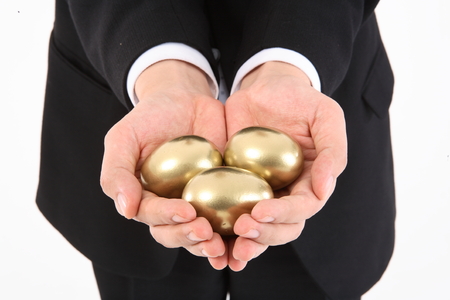 Man holding golden eggs in handsの写真素材