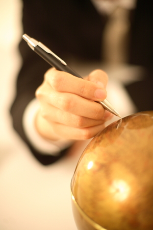 Man marking on a globeの写真素材