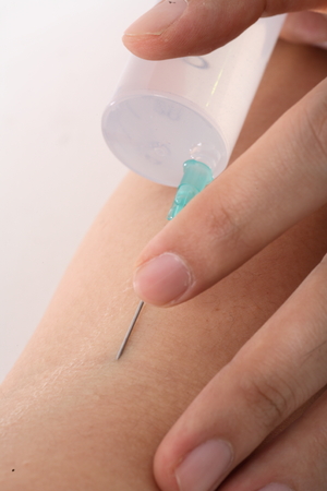 Close-up shot of hands with an injectorの写真素材