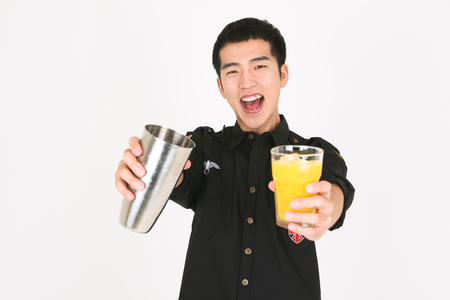 A male bartender with completed cocktailの写真素材