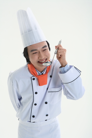 A male cook tasting with a metal ladderの写真素材