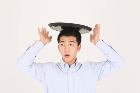A young waiter holding an emptry tray