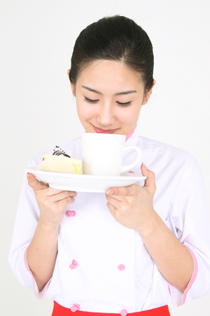 A female cook carrying a dessert plateの写真素材