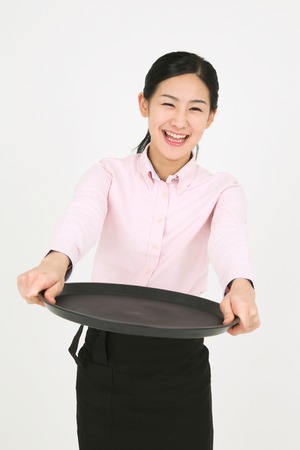A young waitress holding a trayの写真素材