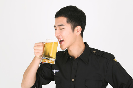 A male bartender holding a glass of beerの写真素材