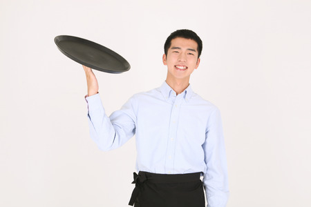 A young waiter holding an emptry trayの写真素材