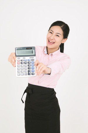 A young waitress holding a calculatorのeditorial素材