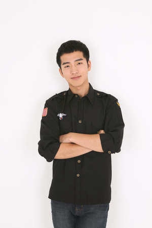 A male bartender standing with arms crossed