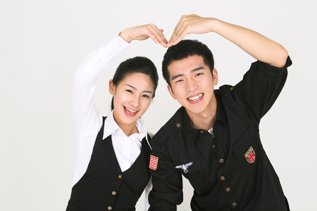 A male bartender and a female bartender making a heart with armsのeditorial素材