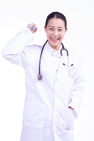 A female doctor holding an injection as the other hand in the pocketの写真素材