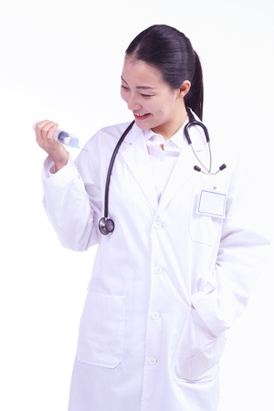 A female doctor holding an injection as the other hand in the pocketの写真素材