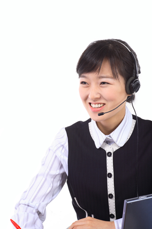 A femlae telemarketer taking a note while responding to the customerの写真素材