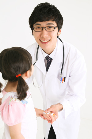 A male doctor diagnosing a child patientの写真素材