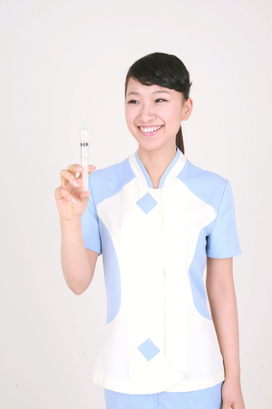 A female nurse holding an injection in handの写真素材