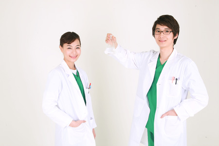 A couple of surgeon looking at a flask togetherの写真素材