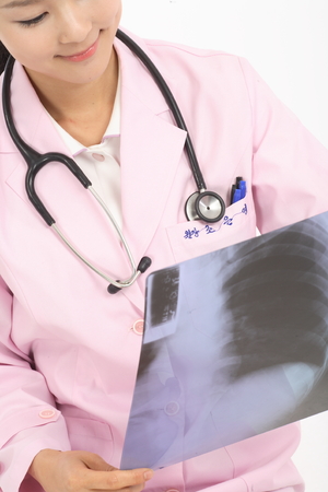Close up shot of Isolated shot of a female doctor in pink robe holding an x-ray photographの写真素材