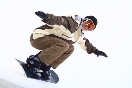 Front shot of A male snowboarder wearing ski goggles snowboarding as squatting downのeditorial素材
