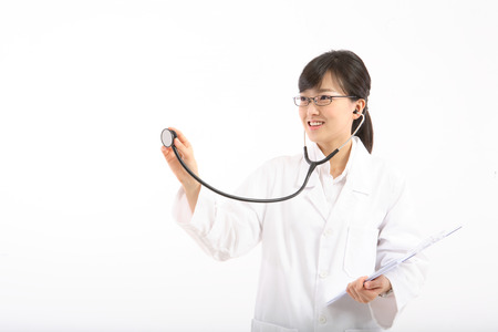 A female doctor pretending to apply the stethoscope as holding a patient chart in handの写真素材