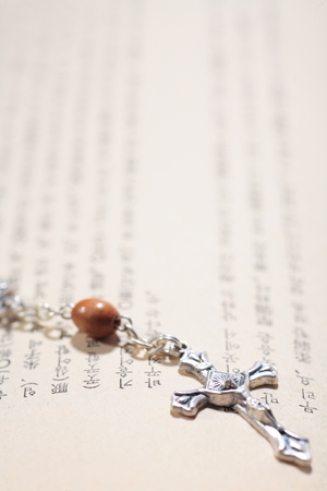 Isolated shot of the rosary laid on the bibleの写真素材