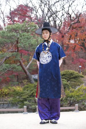 Young Asian man in Hanbok, Korean traditional clothes posing in Hanok, Korean traditional houseの写真素材