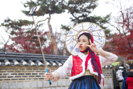 Young Asian woman in Hanbok, Korean traditional clothes posing in Hanok, Korean traditional houseの写真素材