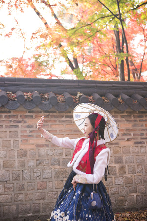 Young Asian woman in Hanbok, Korean traditional clothes posing in Hanok, Korean traditional houseの写真素材