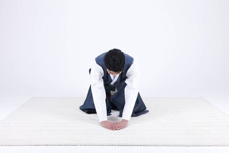 Young Asian man in Hanbok, Korean traditional clothes, posing in the studio - isolated on whiteの写真素材