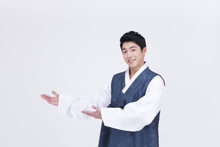 Young Asian man in Hanbok, Korean traditional clothes, posing in the studio - isolated on whiteの写真素材