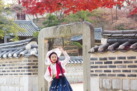 Young Asian woman in Hanbok, Korean traditional clothes posing in Hanok, Korean traditional houseの写真素材